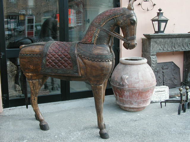 Cavallo antico di legno, orcio toscano dell'Impruneta, caminetto in pietra.